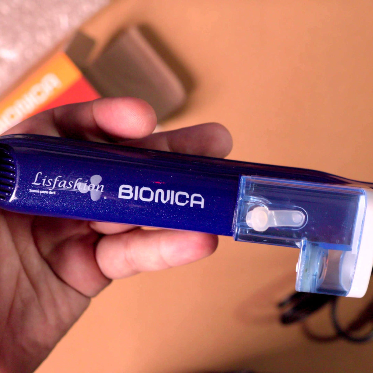 Primer plano del logo Lisfashion Biónica y el tanque transparente para ampolleta líquida